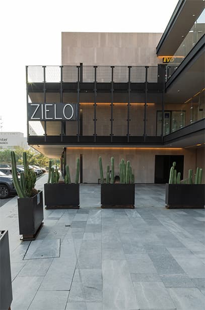 Fachada lateal de plaza zielo con logo en planta alta